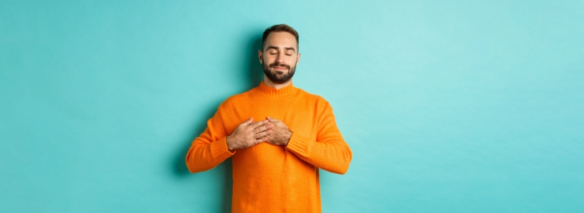 Handsome man feeling nostalgic holding hands heart daydreaming remember imaging something